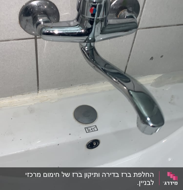 ברז כרום מותקן על קיר מעל כיור לבן